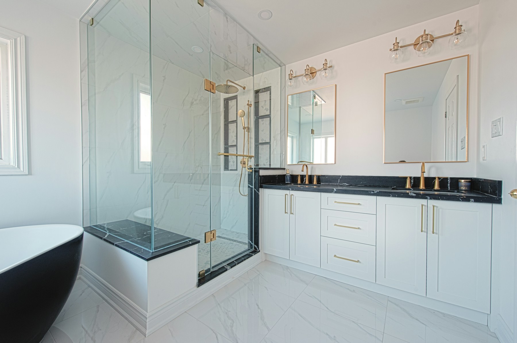 Bright remodeled bathroom with glass shower and tailored cabinetry